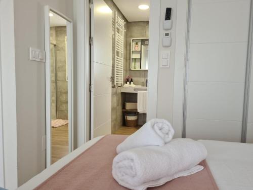 - une salle de bains pourvue de serviettes blanches assises sur un lit dans l'établissement Palmito Luxury La Torre Golf Resort Murcia, à Roldán