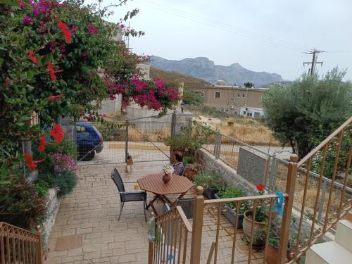 a patio with a table and chairs and flowers at Seaside Apartments 1 in Emborios