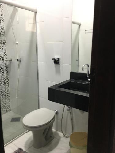 uma casa de banho com um WC, um chuveiro e um lavatório. em Vista da Serra em Cavalcante