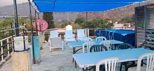 a patio with blue tables and white chairs at Hostal Dulces Sueños in Panajachel