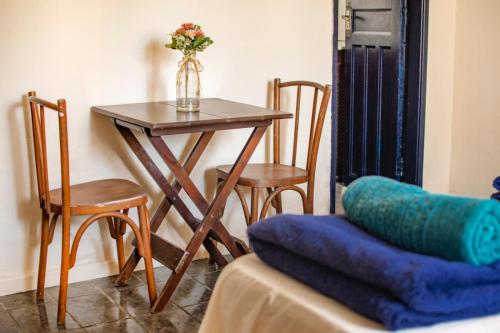 uma mesa e cadeiras com um vaso de flores em Casa Surya Paraty em Paraty