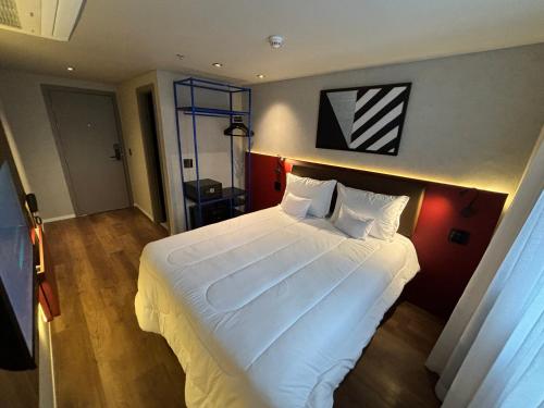 a bedroom with a large white bed in a room at Golden Tower Express Nações Unidas by Fênix Hotéis in Sao Paulo