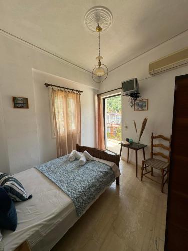 a bedroom with a bed with a chair and a window at Alecos Studios in Poros