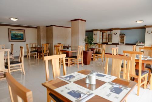 un comedor con mesas y sillas en un restaurante en Hotel Santa Monica en Cuenca