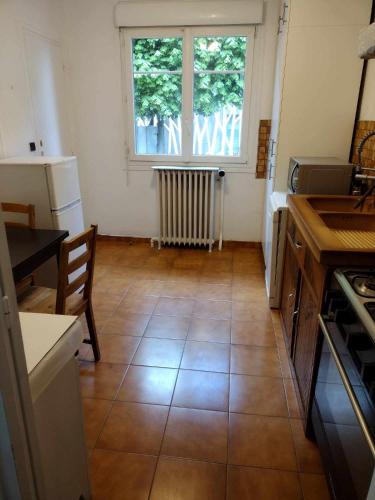 Il comprend une cuisine dotée de carrelage et d'une fenêtre. dans l'établissement 1 Chambre Privée 1 à 2 Voyageurs ,Cuisine & Toilette Partagées ,1 Room Private 1 at 2 Guests,Shares Kitchen &Toilet, à Vitry-sur-Seine