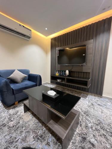 a living room with a couch and a tv at درة السلطان للشقق الفندقية in AlUla