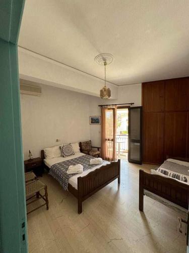 a large bedroom with two beds and a kitchen at Alecos Studios in Poros