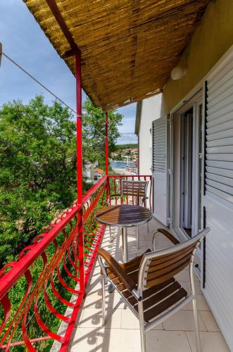 a balcony with two chairs and a table on it at Rooms Ante in Vrboska