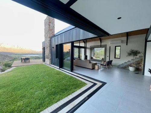 a house with a large patio with a green lawn at The Unbound - Escape the Ordinary in Romansrivier