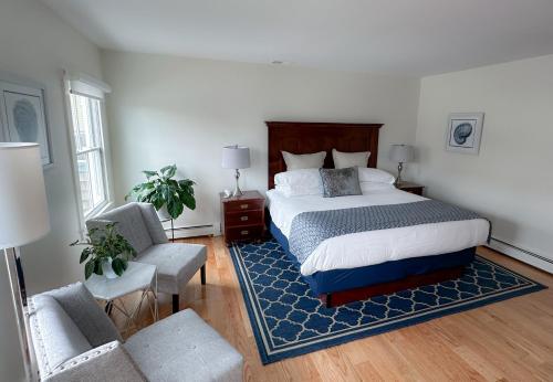 a bedroom with a bed and a couch and a chair at Harborside Inn in Newport
