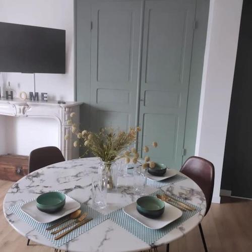 - une table à manger avec une table et des chaises en marbre dans l'établissement Perle Verte, à Malo-les-Bains