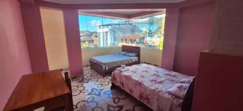 a small room with two beds and a window at HOSPEDAJE EL CANTARO II in Tingo María