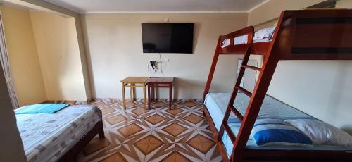 a bedroom with two bunk beds and a flat screen tv at HOSPEDAJE EL CANTARO II in Tingo María