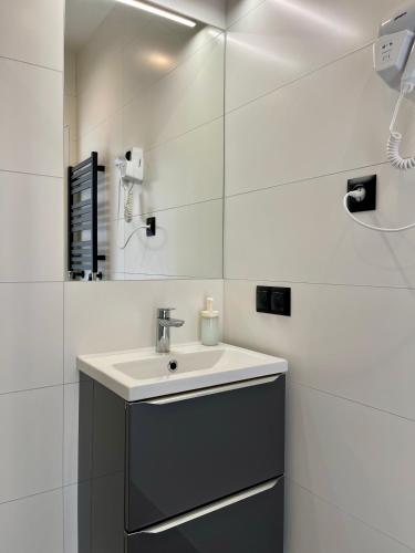 a bathroom with a sink and a mirror at Apartamenty Sopot19 in Sopot