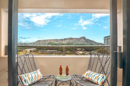 two bottles of beer sitting on chairs on a balcony at Newly Renovated 2 Bedroom Condo, 1 Block to Waikiki Beach, Free Parking in Honolulu