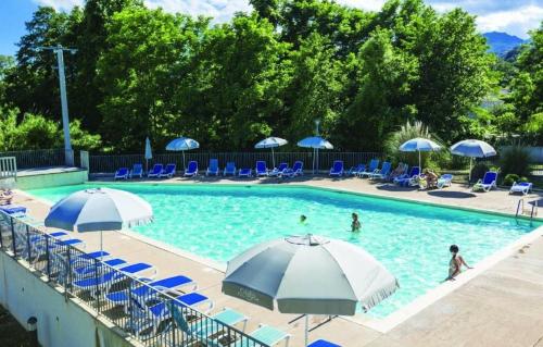 une piscine avec des chaises bleues et des parasols dans l'établissement Appartement T3 bord de mer résidence Aqualinda E55, à Poggio-Mezzana