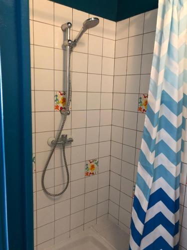 une salle de bain avec une douche avec un rideau de douche dans l'établissement Au coeur du 18eme arrondissement proche de Montmarte et des Jeux Olympiques, à Paris