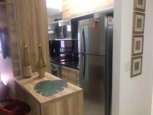a kitchen with a stainless steel refrigerator and a counter at Apartamento Aconchegante para sua Viagem in Rio de Janeiro