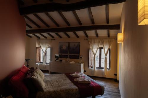 Mansarda Pescia في بيسيا: غرفة نوم مع سرير في غرفة مع نوافذ