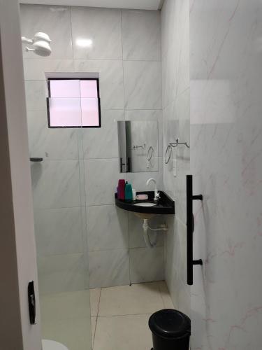 a white bathroom with a shower and a sink at Quarto de apartamento no Centro de Caruaru in Caruaru