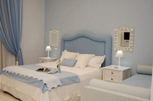 - une chambre bleue et blanche avec un lit et une chaise dans l'établissement Domus Rosa, à Naples