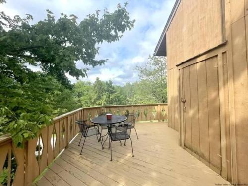 a wooden deck with a table and chairs on it at Hunter Mountain Slope Side Home in Lanesville