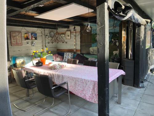 a dining room with a pink table and chairs at Vakantie Studio Grou in Grou