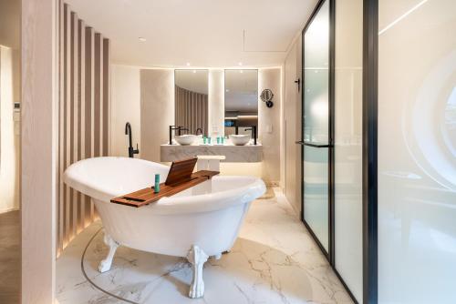 y baño con bañera blanca y lavamanos. en Hotel Unique, en São Paulo