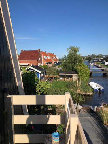 a balcony with a view of a river and houses at Vakantie Studio Grou in Grou