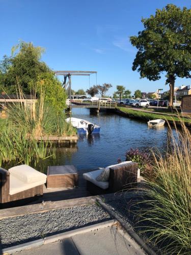 a river with a boat in the water at Vakantie Studio Grou in Grou