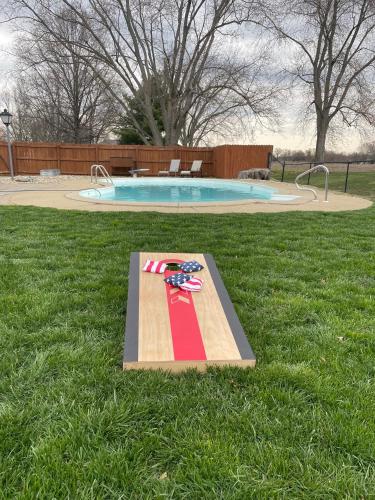 a wooden skateboard in the grass next to a pool at Hometown Hideaway - 4br25ba, Pool, Game Room in Greenwood