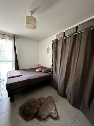 une chambre avec un lit et un tapis au sol dans l'établissement Le Lironde - charmant F2, à Montpellier