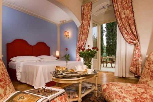 sypialnia z łóżkiem, stołem i krzesłem w obiekcie Villa la Borghetta Spa Resort w mieście Figline Valdarno