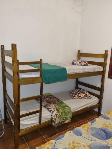 two bunk beds in a room with a floor at Hostel Sepumpá Sepápum in Itanhaém