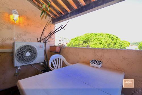 Le Grand Large في سانت-ماندرييه-سور-مير: غرفة بها طاولة ومروحة على شرفة