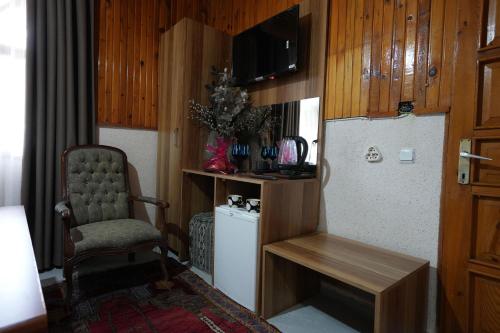 a living room with a chair and a small refrigerator at OzenTurku Hotel in Pamukkale