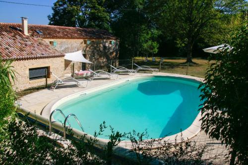 une grande piscine bleue à côté d'un immeuble dans l'établissement Grande Maison de vacances avec piscine privée pour 12 personnes max, à Mauzac-et-Grand-Castang