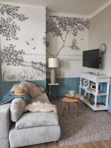 un salon avec un canapé et une télévision dans l'établissement Rêves Salés, à Malo-les-Bains