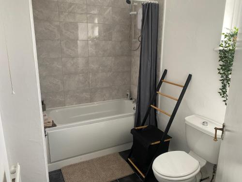 a bathroom with a white tub and a toilet at Modern Manchester home, Free parking & near city centre in Manchester