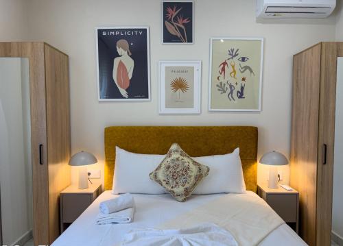 a bedroom with a bed with two lamps and pictures on the wall at Loridis Central Apartments in Prinos