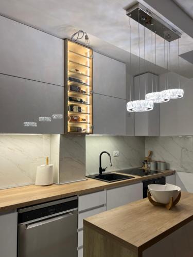 a kitchen with a sink and a counter with wine bottles at Stan na dan,Beograd -Žarkovo in Bele Vode