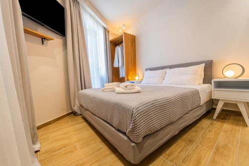 a bedroom with a bed with two towels on it at Iridium Old Town Luxury Suites in Kavala