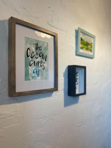 a picture hanging on a wall with two pictures at Clarefornia Stone Shed in Lahinch