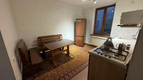 eine Küche mit einer Bank, einem Tisch und einem Herd in der Unterkunft Parusa Burgulyuk in Birgulyuk