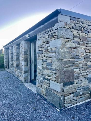 a stone building with a door on the side of it at Clarefornia Stone Shed in Lahinch