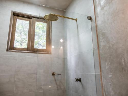 a bathroom with a shower with a window at Salvia Madre Hotel Boutique in Guachaca