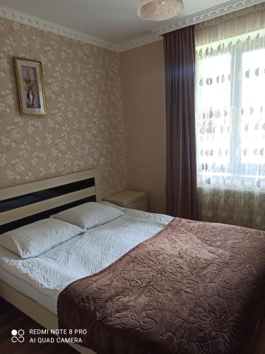 a bedroom with a bed and a window at Crystal Kazbegi in Stepantsminda