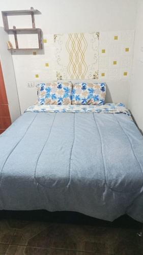 - un lit avec des draps et des oreillers bleus dans l'établissement HABITACIONES ISABEL, à Lima