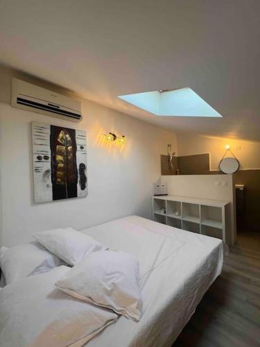 - une chambre avec un grand lit blanc et une lumière dans l'établissement Magnifique T3 duplex, à Aubagne