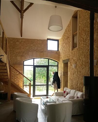 un salon avec un canapé blanc et des chaises dans l'établissement Grande Maison de vacances avec piscine privée pour 12 personnes max, à Mauzac-et-Grand-Castang